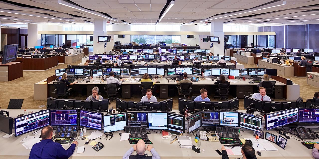  Liberty trading floor wide angle shot of traders at desks looking at computers.