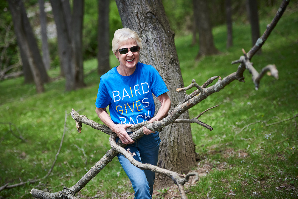 Liberty leadership team member carrying tree branches while volunteering.